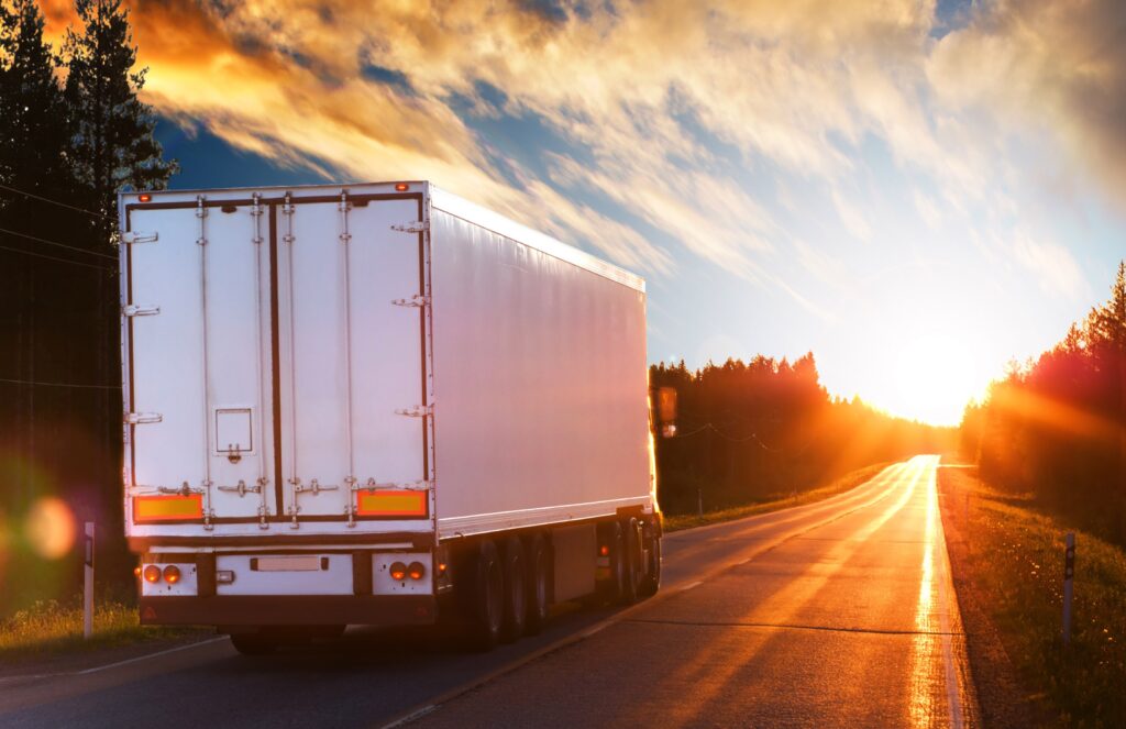 White truck on an asphalt road in the evening