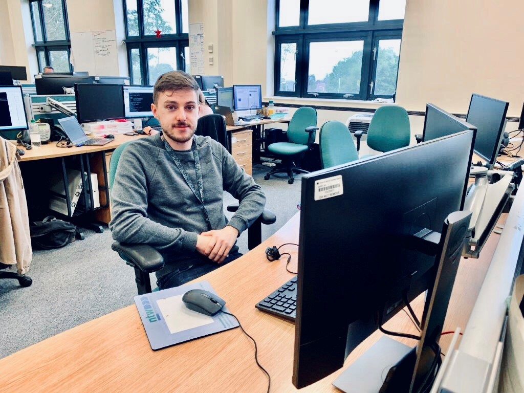 James sitting at his desk in front of a PC