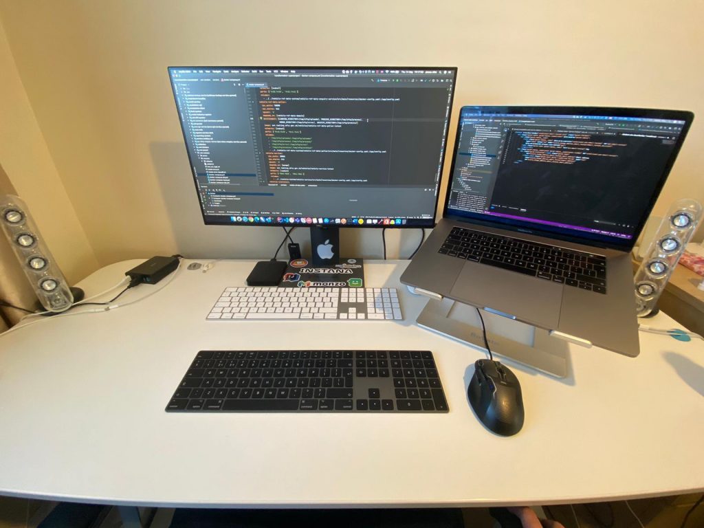 Photo of James' computer screen and laptop at home with lines of code on them