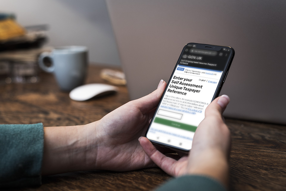 Person looking at the Self-employment Income Support Scheme page on GOV.UK on their mobile phone