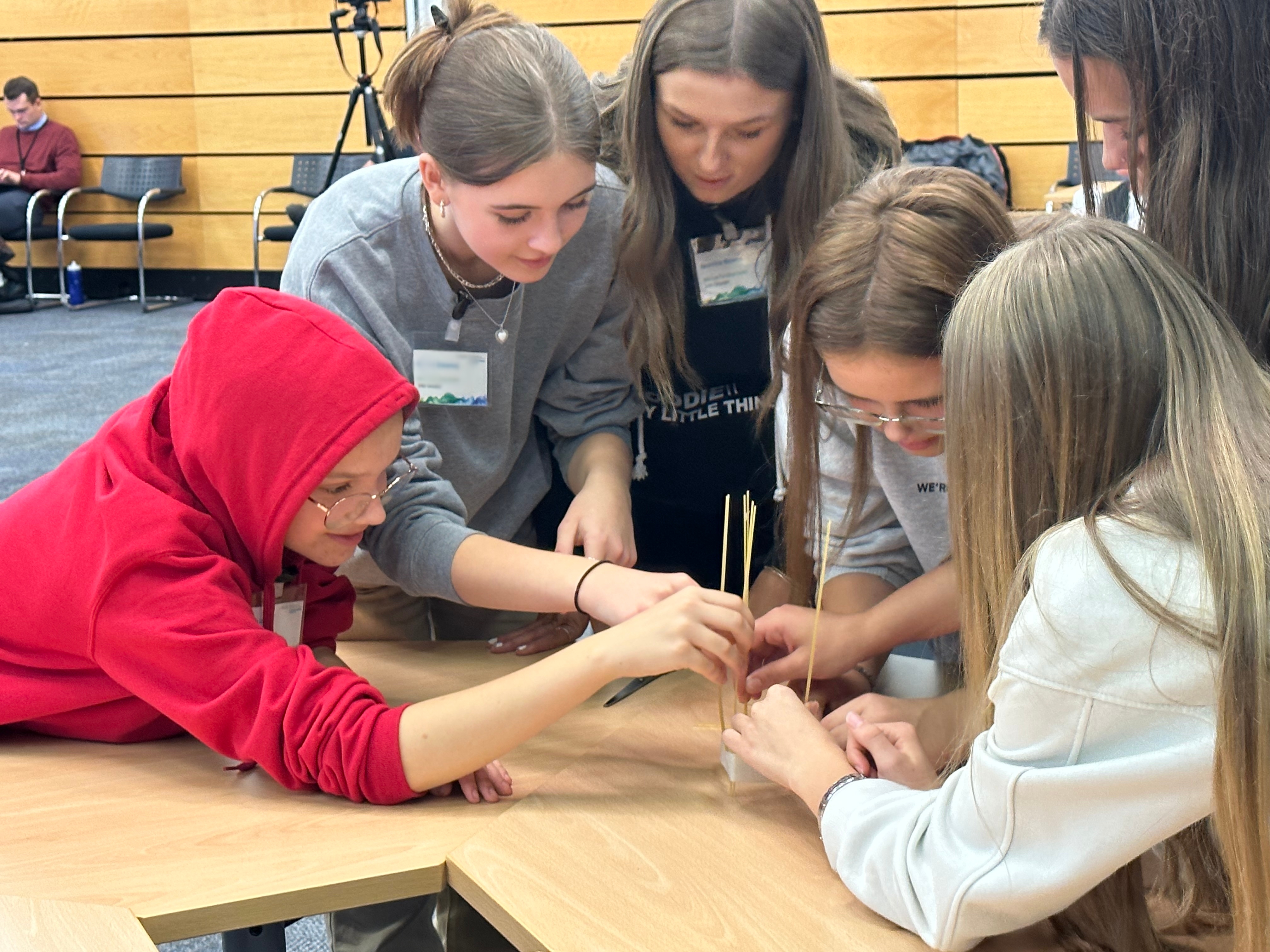 A group of girls around a table participating in an activity,